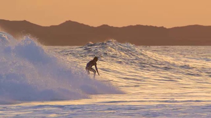 慢动作: 冲浪者花花公子在五颜六色的夏日日落时雕刻大破浪。