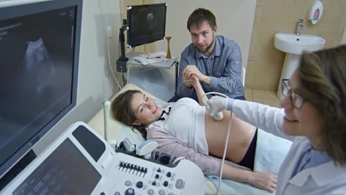 男子在超声波测试期间支持怀孕的妻子