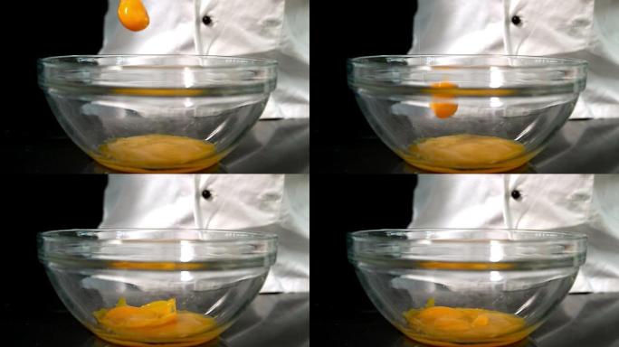 厨师将生鸡蛋添加到玻璃碗中