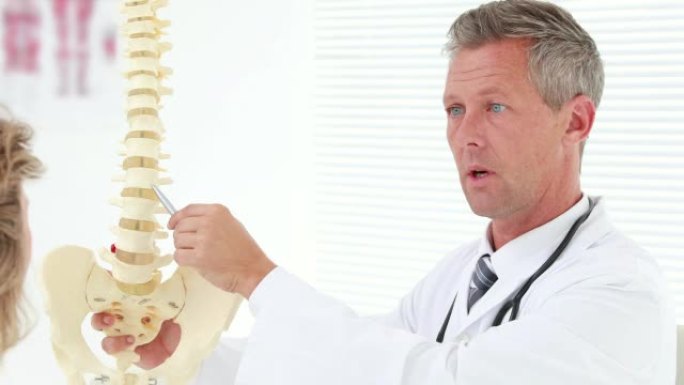 物理治疗师向患者解释脊柱模型