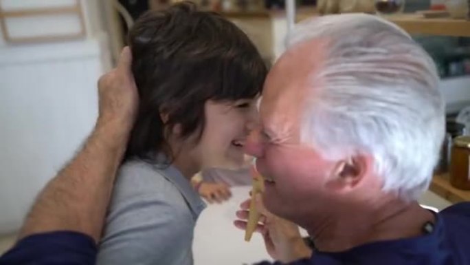 可爱的孙子孙女用冰淇淋让他们的祖父母感到惊讶，祖父母亲吻他们非常开心和微笑