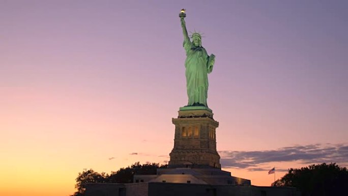 近距离观察著名的自由女神像在日落时被火红的天空照亮