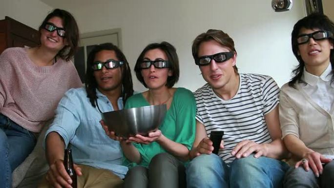 朋友们在沙发上戴着3D眼镜看电视