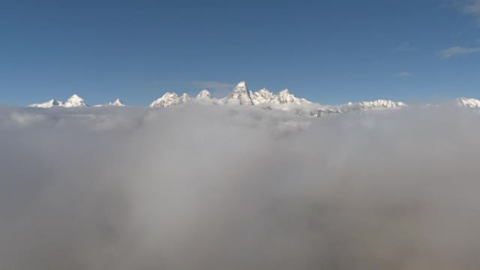 空中: 雄伟的白雪皑皑的大提顿山峰消失在雾和云中