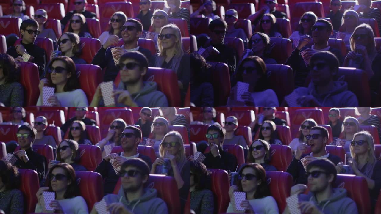 一群戴着3d眼镜的人正在电影院观看电影放映。