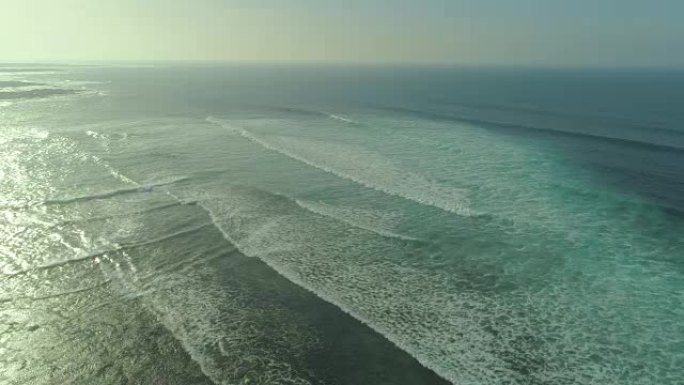 空中: 晶莹剔透的光滑波浪从很远的地方慢慢接近海岸。