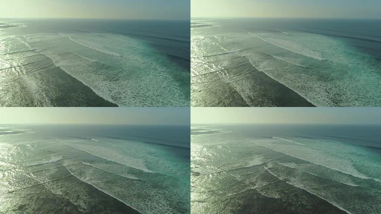 空中: 晶莹剔透的光滑波浪从很远的地方慢慢接近海岸。