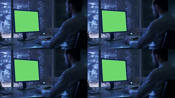深夜，一个商人在他的私人办公室里用一台带有绿色模拟屏幕的个人电脑工作，可以看到大城市的窗户。