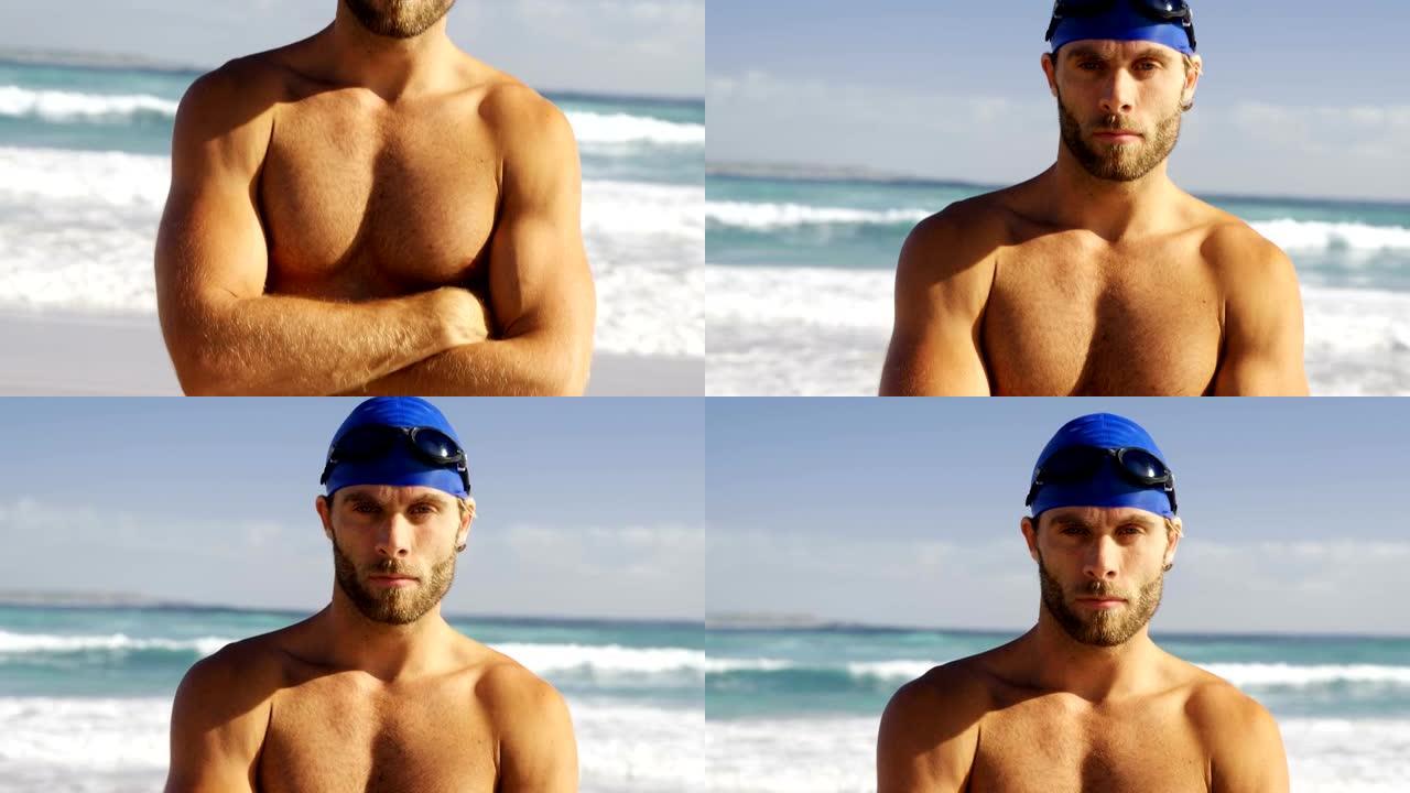 男性冲浪者站在海滩上双臂交叉的肖像
