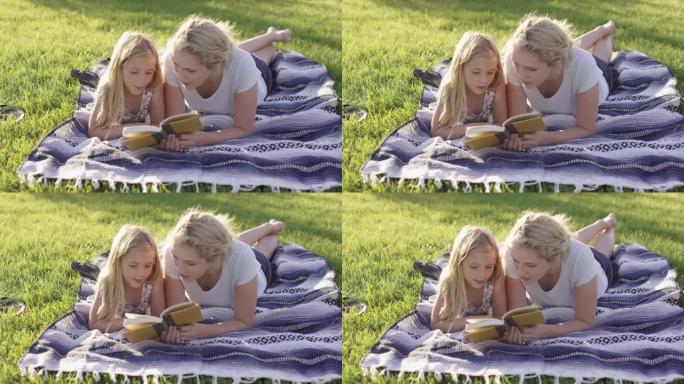 母女俩在外面的毯子上看书