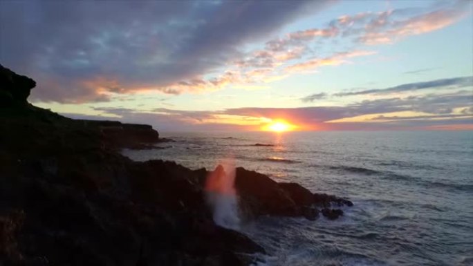 空中慢动作: 日落时分海浪袭击多岩石的海岸