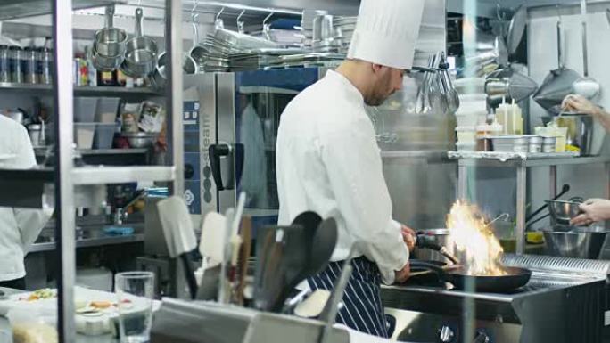 餐厅或酒店的商业厨房中的三名专业厨师正在准备食物。