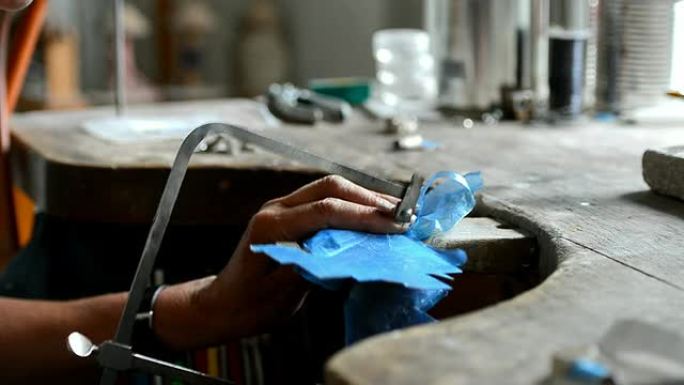 女珠宝商用锯切割金属