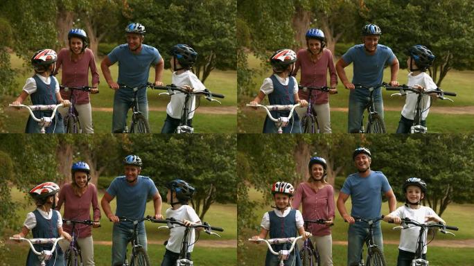 公园里骑自行车的幸福家庭对着镜头微笑