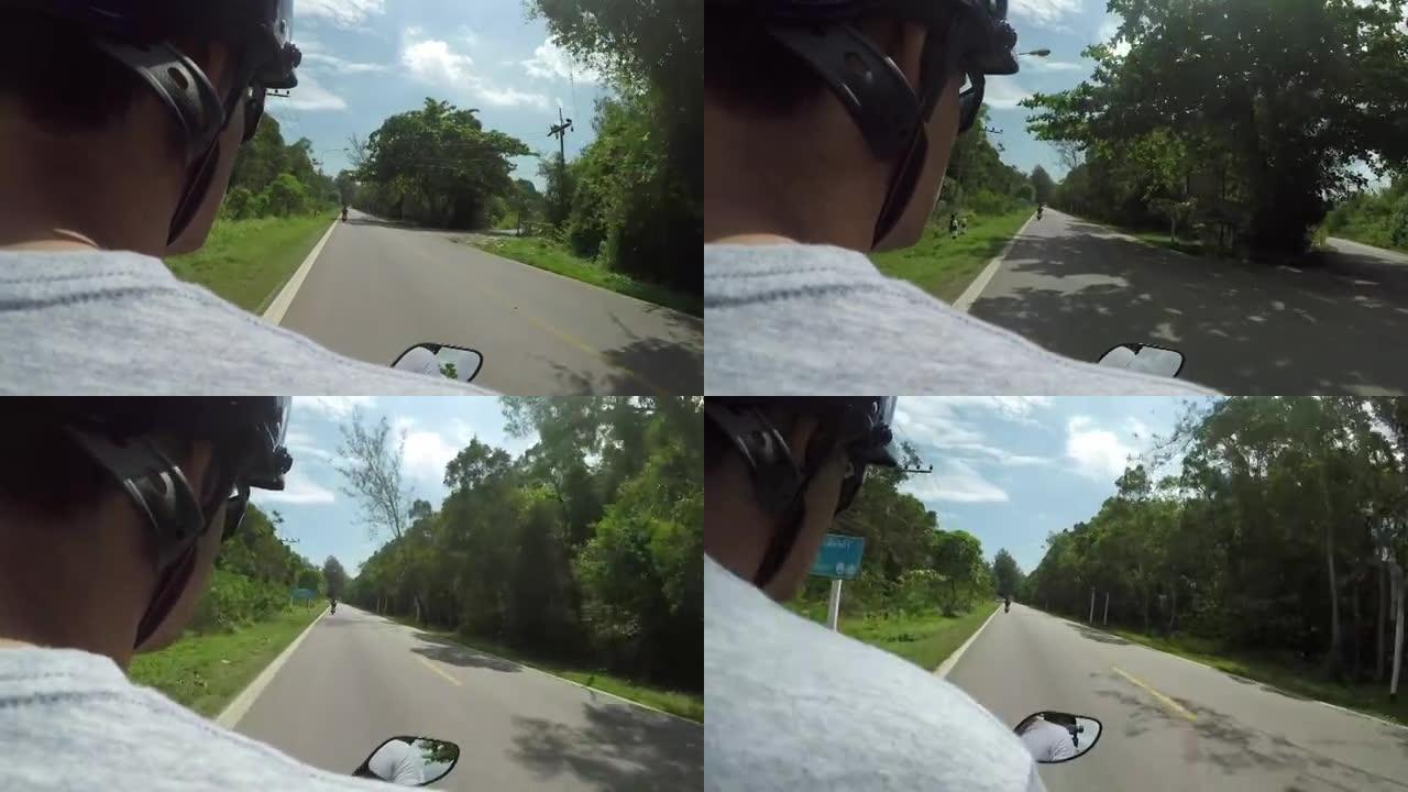 POV: 坐在年轻的男司机后面的踏板车上，沿着狭窄的异国情调的道路骑行。