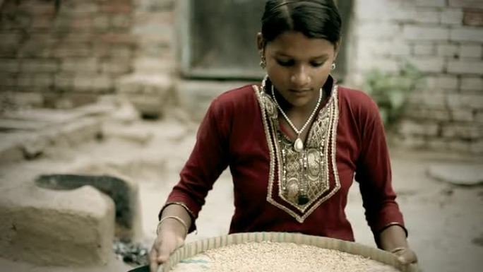 真实的印度农村人：正在筛选小麦粒的少女。