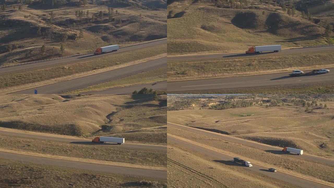 空中: 半卡车和汽车沿着风景秀丽的乡村丘陵景观高速公路行驶