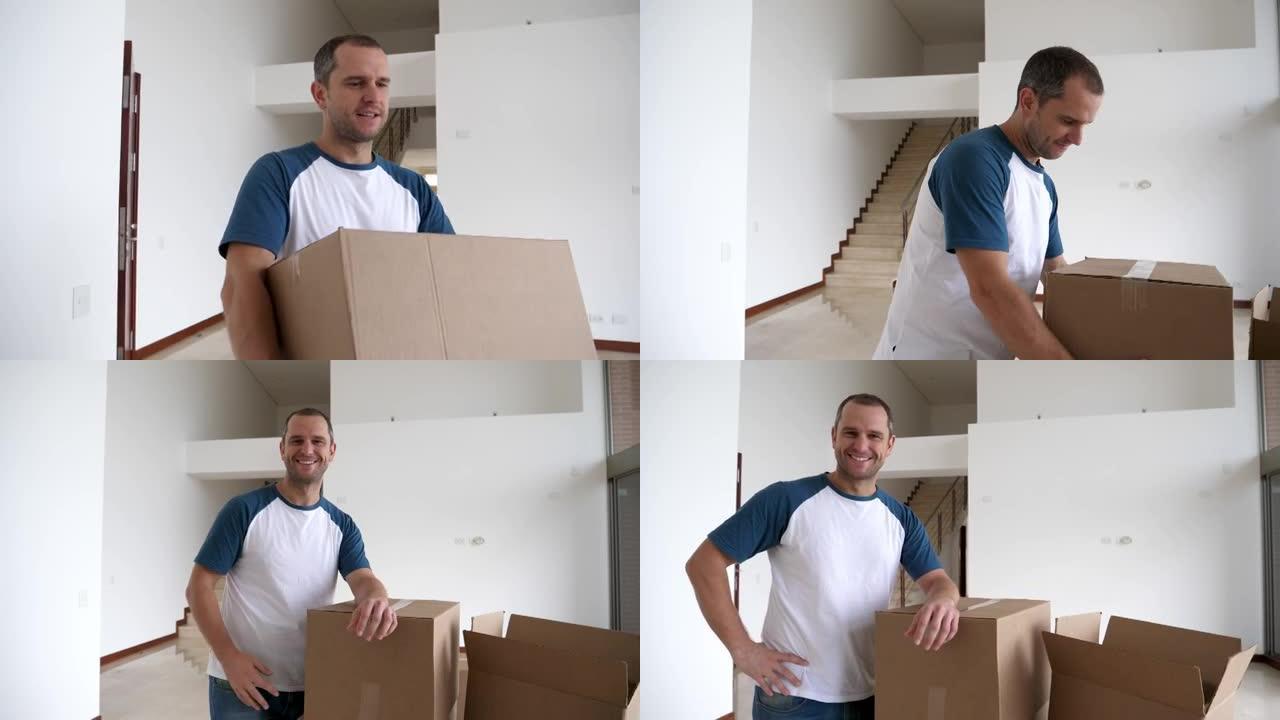 英俊的单身男子把箱子搬进新家，然后看着相机微笑
