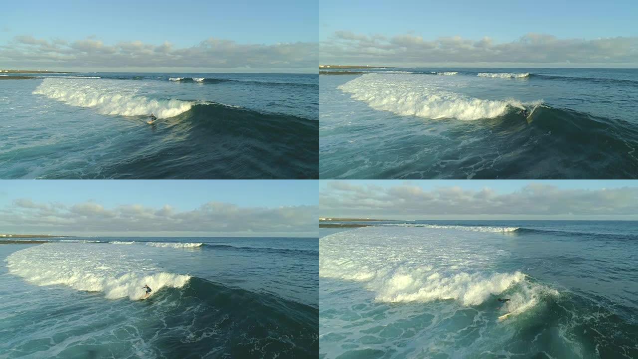 空中慢动作: 职业冲浪者在日出时在富埃特文图拉岛骑着泡沫波。