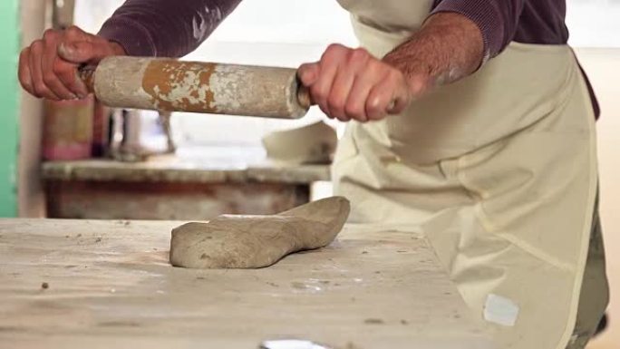带有rolling面杖的男性陶工成型粘土