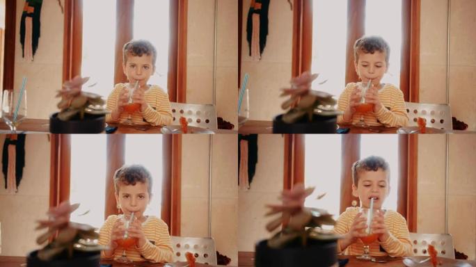 小男孩在吃完早餐前喝新鲜橙汁