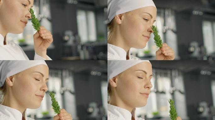 美丽的年轻女厨师闻到装饰香料植物。