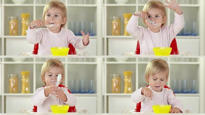 高清: 快乐的小女孩用勺子吃饭