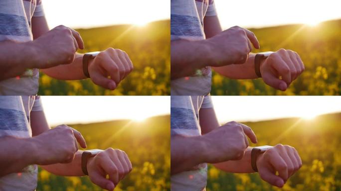 男子在日落时在花场使用智能手表