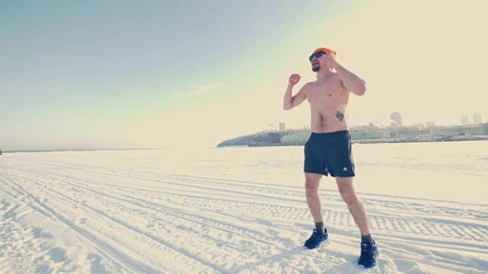 一个穿着运动短裤的男人在冬天在外面变暖。