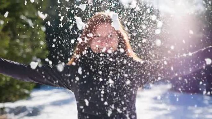 年轻女子向空中扔雪