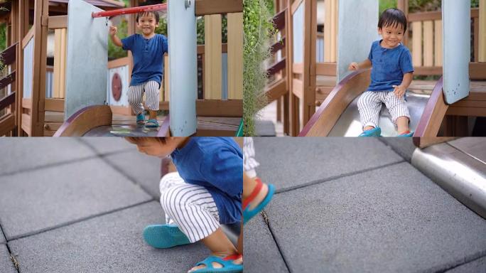 SLO MO开朗的亚洲小男孩从儿童滑梯上走下来。