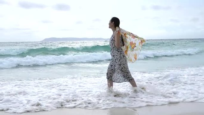 戴着围巾在海上行走的年轻女子