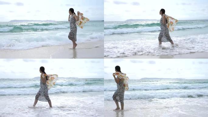 戴着围巾在海上行走的年轻女子