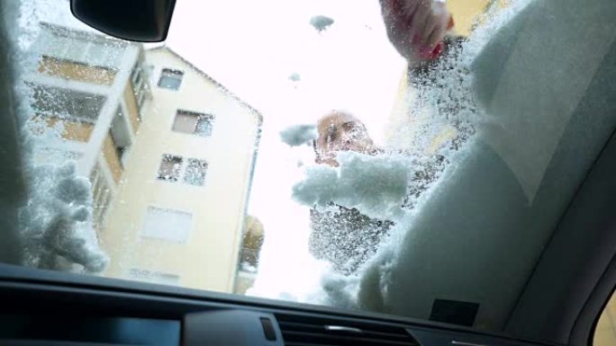 女人从汽车上除雪