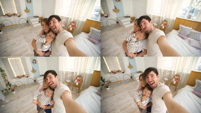 幸福家庭的父亲在卧室的相机上拍摄自拍视频