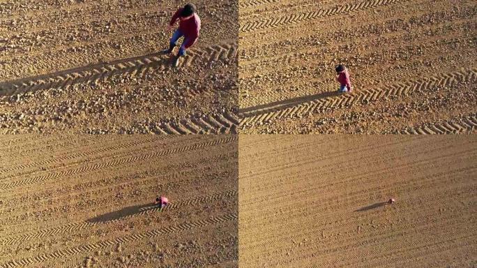 MS到WS航拍农民检查在阳光充足的，农村耕地的泥土