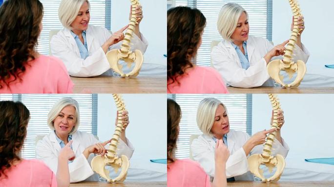 女医生向女性患者解释脊柱模型