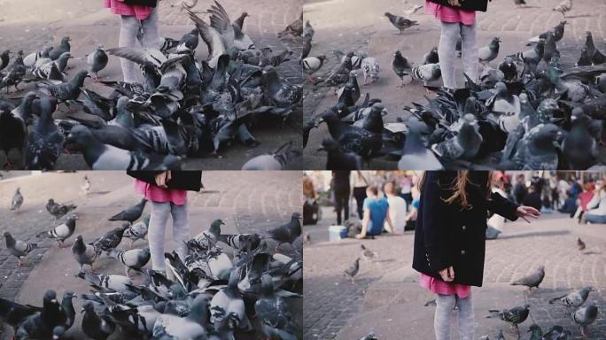 被鸟儿包围的欧洲小女孩。慢动作。兴奋可爱的女孩子看着城市广场的大鸽子群