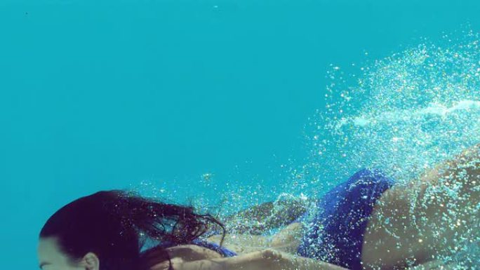 穿着蓝色泳衣的女人在水下游泳