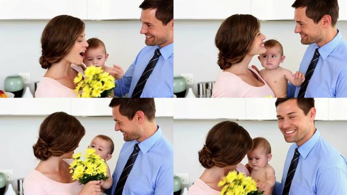 父亲惊讶母亲抱着黄色花朵的婴儿