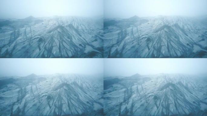 冰岛黑灰白色冰川Myrdalsjokull的鸟瞰图。直升机在雾中飞越冰山