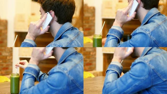 男人喝果汁时在手机上聊天