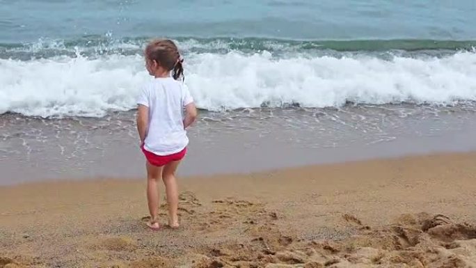 小女孩在海滩上玩海浪