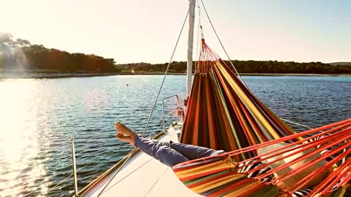 SLO MO女人在帆船上的吊床上放松