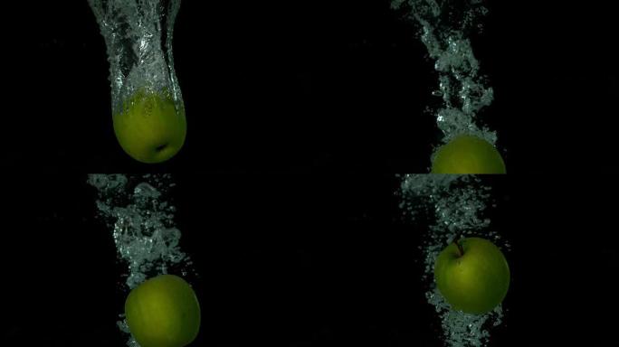 绿色苹果在黑色背景下陷入水中