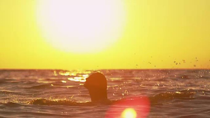 慢动作: 女人在日落海洋中泼水