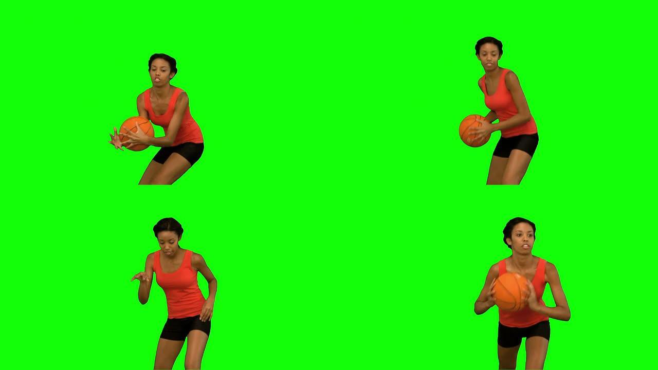 女人在绿屏上接球并扔篮球