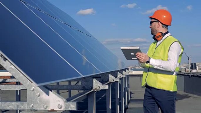 一名男性工作服专家正在检查太阳能电池板