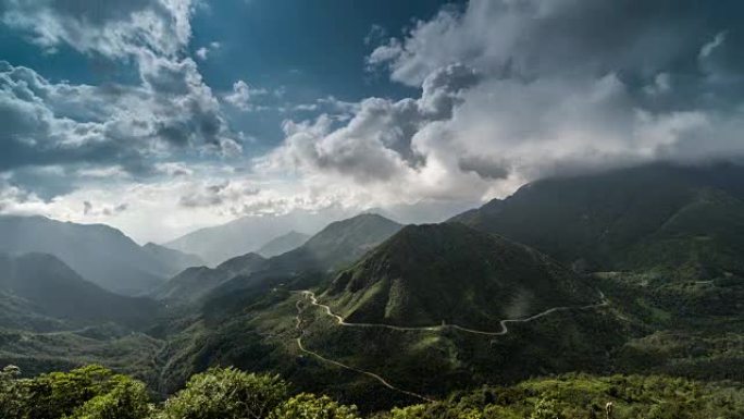 延时景观攀登山脉的精彩镜头。高岩山区迷雾山路上多云的天空和阳光