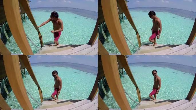 年轻人从一个房间走进大海，马尔代夫的海上度假胜地。